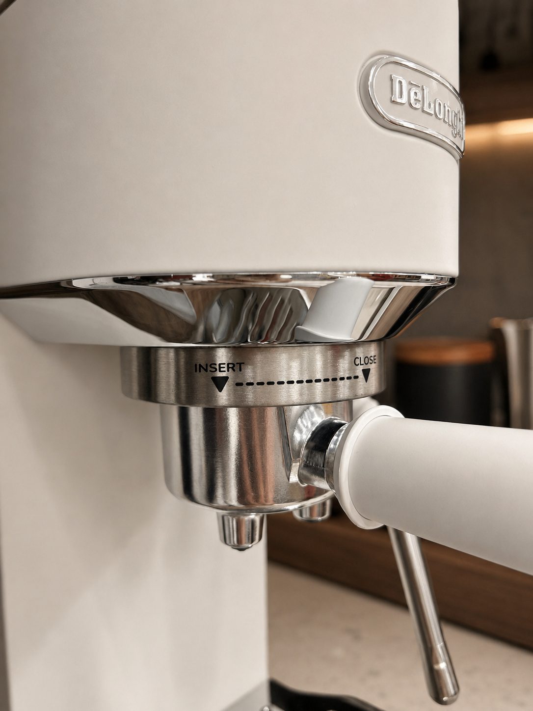 DeLonghi white espresso machine portafilter and steam wand detail